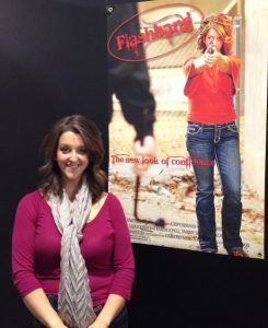 Woman standing with a Flashbang poster